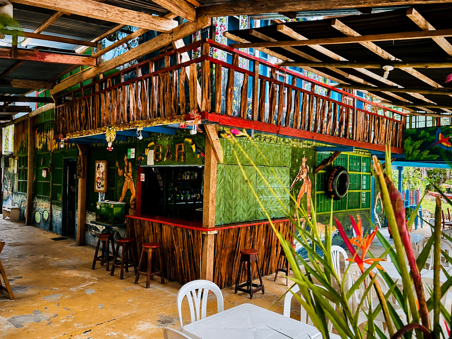 Bar tropical rústico al aire libre con murales amazónicos